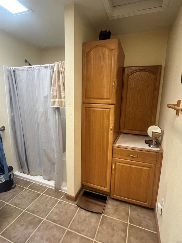 full bath with curtained shower and tile patterned flooring