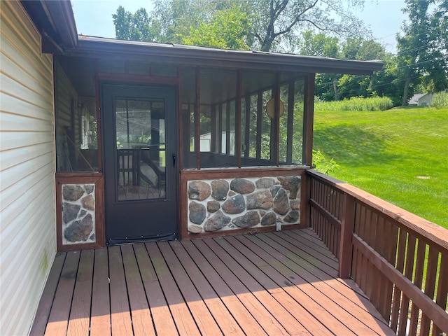 wooden terrace featuring a sunroom and a yard