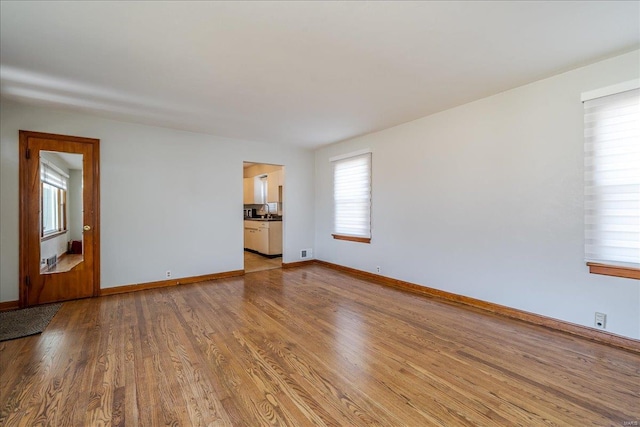 unfurnished room with baseboards and wood finished floors