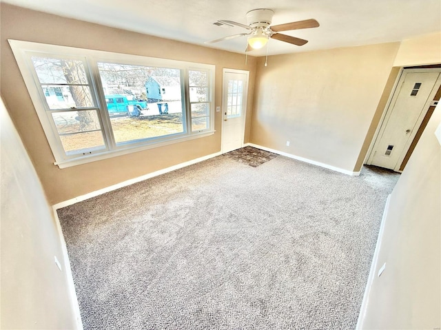 spare room with ceiling fan, carpet floors, and baseboards