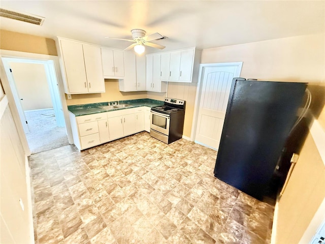 kitchen with visible vents, dark countertops, freestanding refrigerator, stainless steel electric range, and a sink