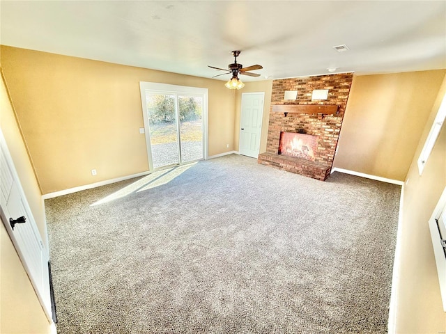 unfurnished living room with ceiling fan, carpet flooring, visible vents, baseboards, and a brick fireplace