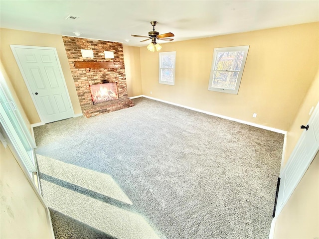 living room with visible vents, baseboards, a ceiling fan, carpet, and a fireplace