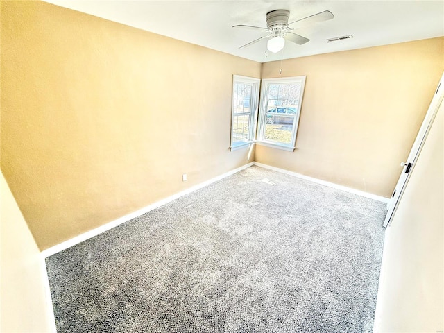 carpeted spare room with visible vents, ceiling fan, and baseboards