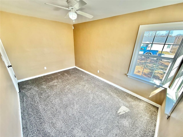 carpeted empty room featuring a ceiling fan and baseboards