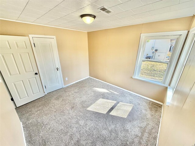 unfurnished bedroom featuring carpet floors, a closet, visible vents, and baseboards