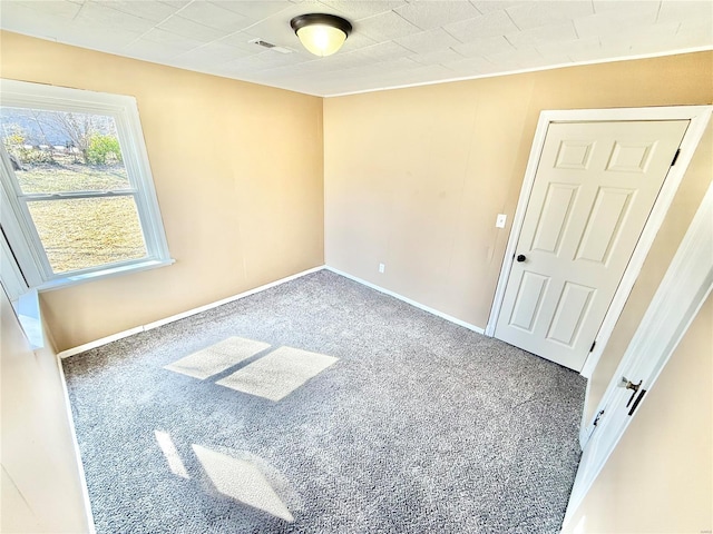 carpeted empty room with baseboards and visible vents