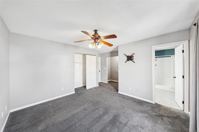 unfurnished bedroom featuring baseboards, dark colored carpet, and a ceiling fan