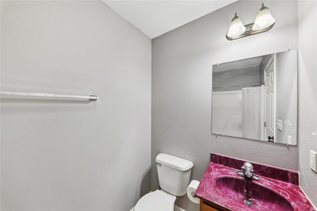 bathroom with toilet, vanity, and a shower with curtain