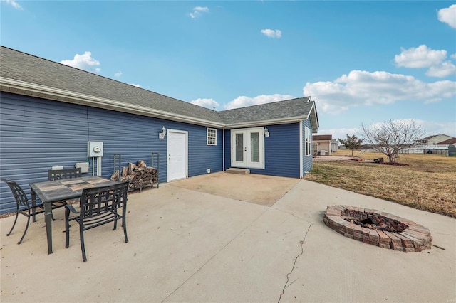 back of house featuring an outdoor fire pit, roof with shingles, a patio, and french doors