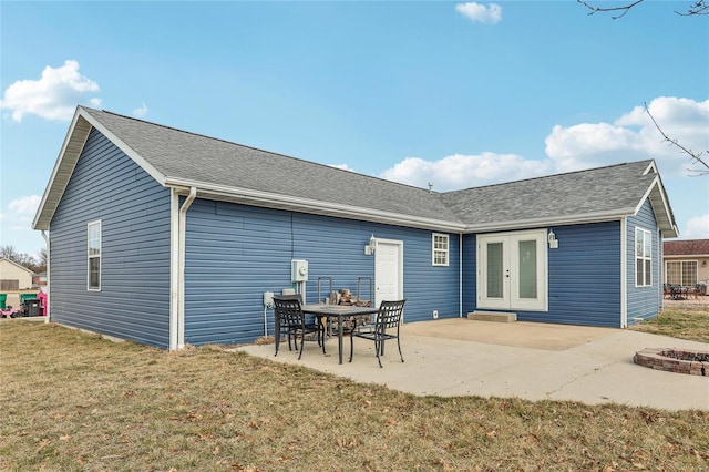 rear view of house featuring a yard, a patio, french doors, and roof with shingles