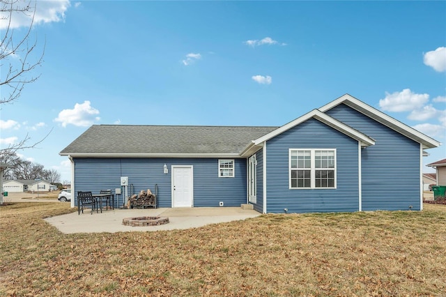 back of house featuring a yard, a patio, and a fire pit