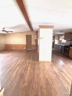 unfurnished living room with beamed ceiling, wood finished floors, and ceiling fan