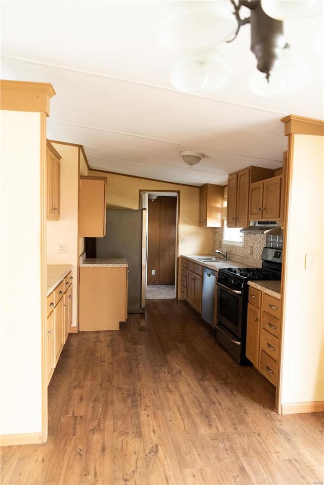 kitchen featuring under cabinet range hood, appliances with stainless steel finishes, light countertops, and wood finished floors