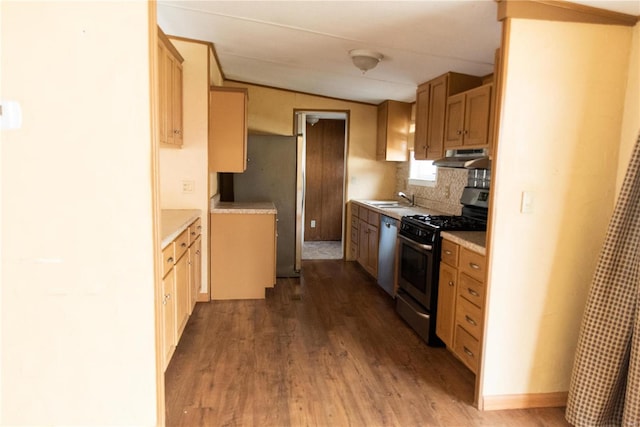 kitchen featuring wood finished floors, a sink, light countertops, under cabinet range hood, and appliances with stainless steel finishes