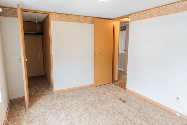 unfurnished bedroom featuring a spacious closet, visible vents, baseboards, carpet, and a closet