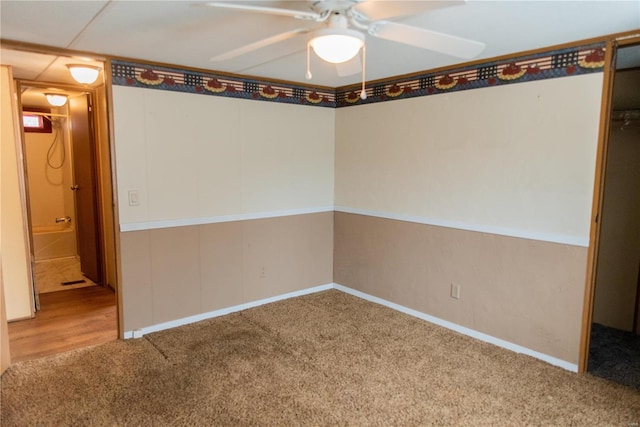 unfurnished room with a ceiling fan and carpet