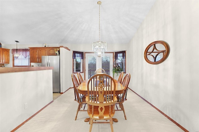 dining area with lofted ceiling, baseboards, and a chandelier