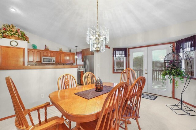 dining space featuring vaulted ceiling, light colored carpet, plenty of natural light, and french doors