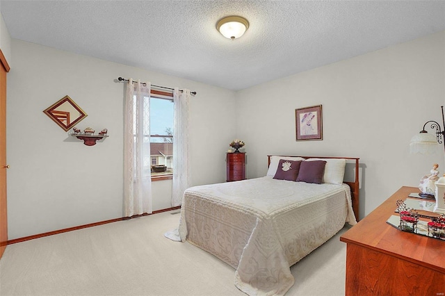 bedroom with carpet, baseboards, and a textured ceiling