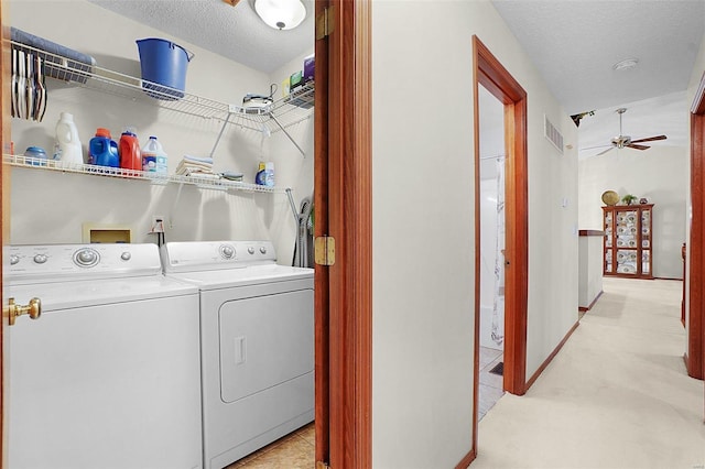 clothes washing area with visible vents, washing machine and dryer, ceiling fan, a textured ceiling, and baseboards