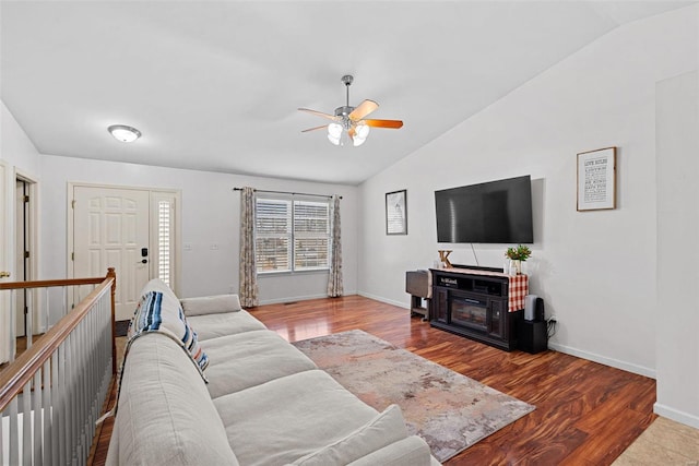 living room with a ceiling fan, lofted ceiling, baseboards, and wood finished floors