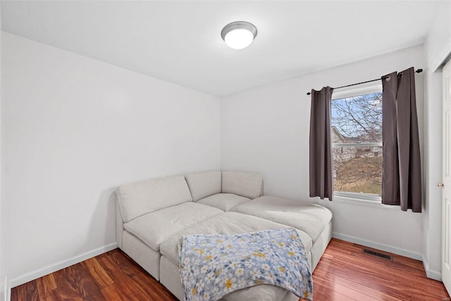 bedroom featuring multiple windows, baseboards, and wood finished floors