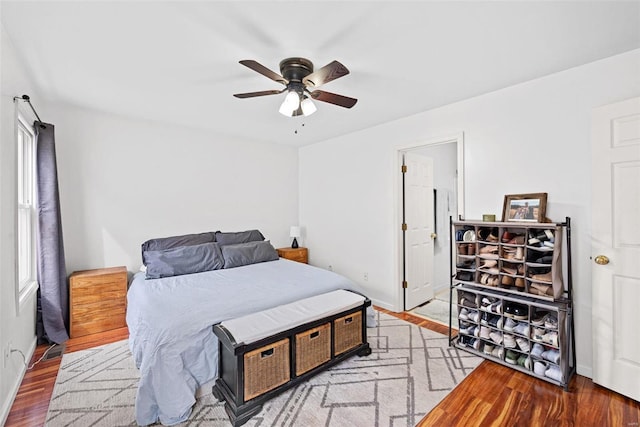 bedroom with ceiling fan, baseboards, and wood finished floors