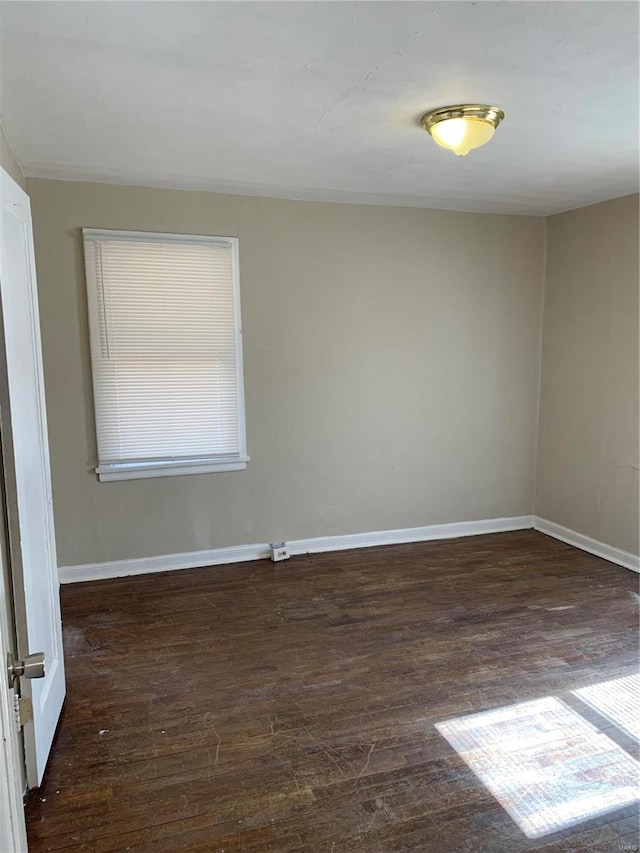 unfurnished room featuring baseboards and wood finished floors