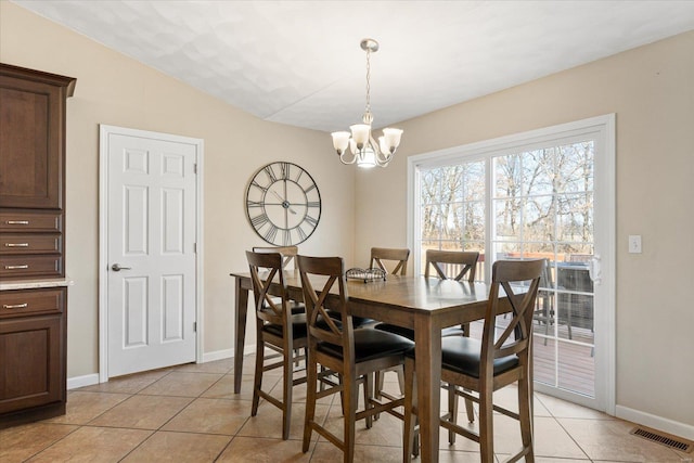 dining room with light tile patterned floors, baseboards, visible vents, and a chandelier