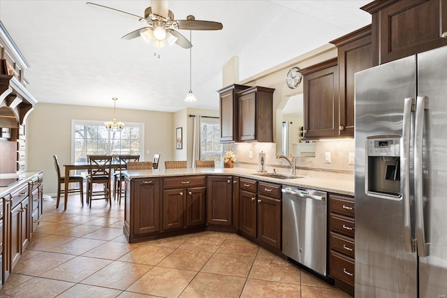 kitchen featuring appliances with stainless steel finishes, backsplash, light tile patterned flooring, and a sink