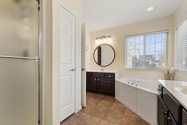 full bath featuring a stall shower, a bath, two vanities, tile patterned floors, and a sink