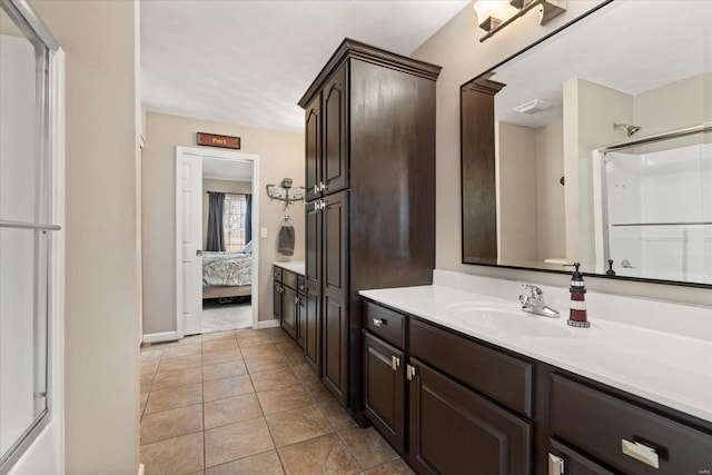 ensuite bathroom with baseboards, ensuite bath, a shower with shower door, tile patterned flooring, and vanity