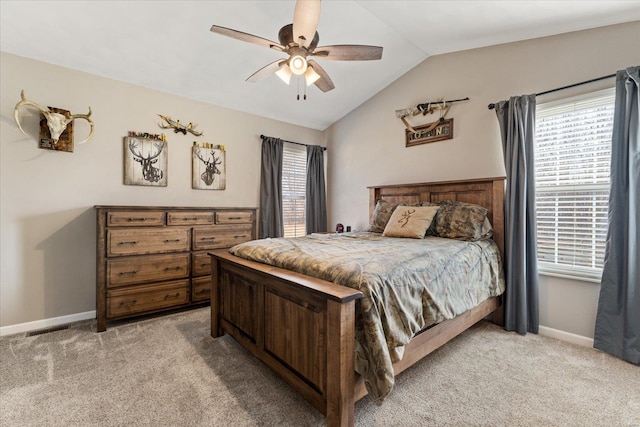 bedroom featuring lofted ceiling, light colored carpet, and multiple windows