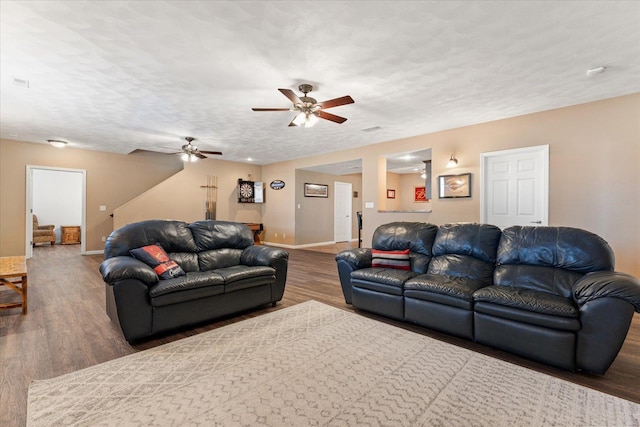 living area featuring a textured ceiling, wood finished floors, and baseboards