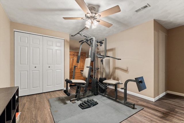 exercise room with visible vents, ceiling fan, baseboards, and wood finished floors