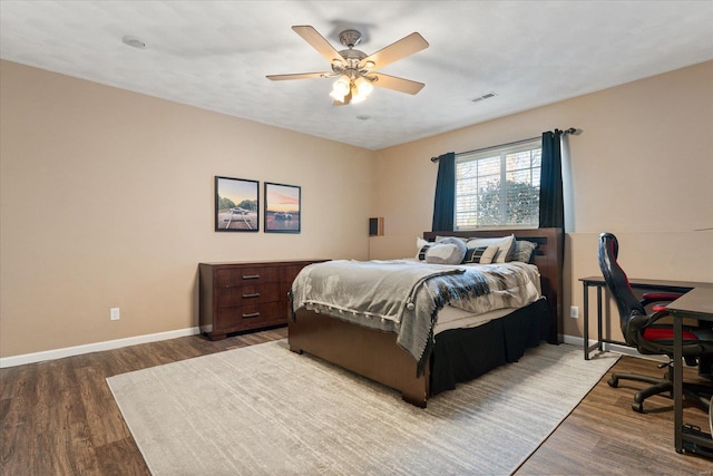 bedroom with visible vents, ceiling fan, baseboards, and wood finished floors