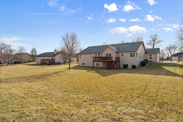 rear view of property featuring a yard, stairway, and a wooden deck