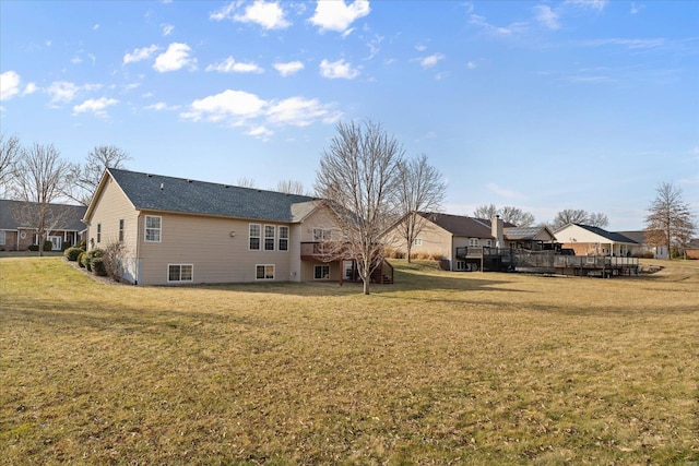 rear view of property featuring a lawn and a wooden deck