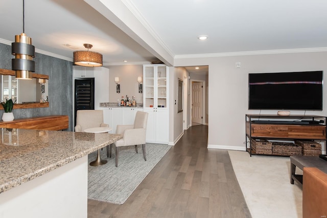 kitchen featuring recessed lighting, ornamental molding, open floor plan, wood finished floors, and beverage cooler