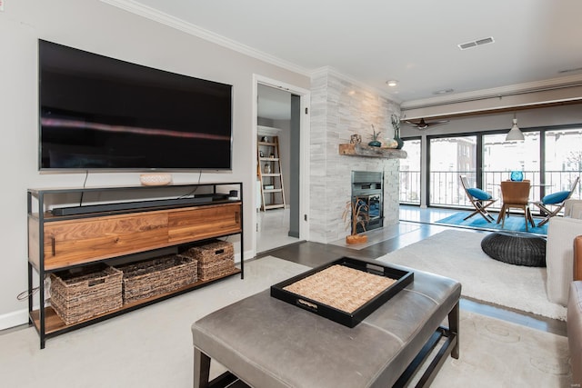 living room with a fireplace, visible vents, baseboards, a ceiling fan, and ornamental molding