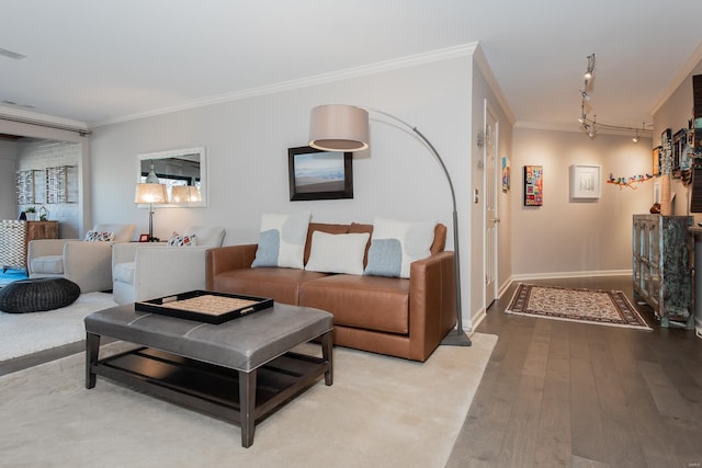 living area featuring baseboards, visible vents, ornamental molding, wood finished floors, and rail lighting