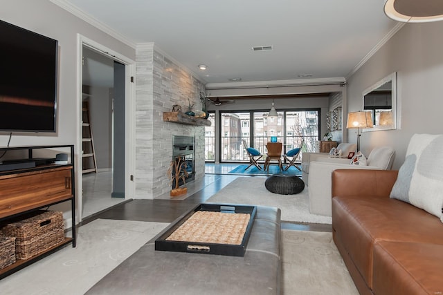 living area with a large fireplace, visible vents, crown molding, and wood finished floors