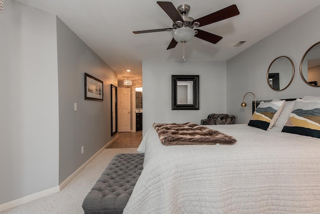 bedroom with light colored carpet, visible vents, connected bathroom, ceiling fan, and baseboards