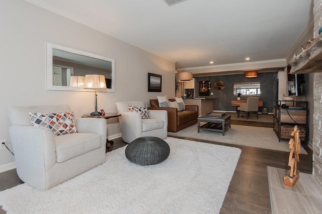 living area featuring baseboards, ornamental molding, and wood finished floors