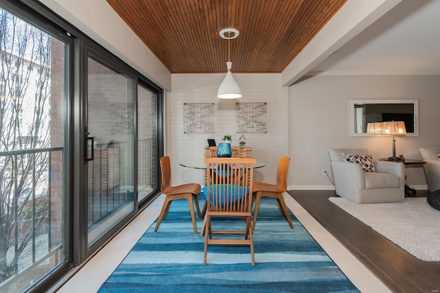 dining space with ornamental molding, wood finished floors, wood ceiling, and baseboards