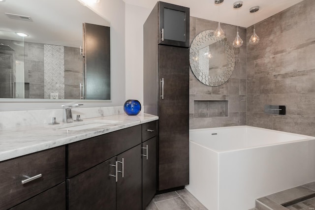 bathroom with visible vents, a bathing tub, vanity, tile patterned flooring, and walk in shower