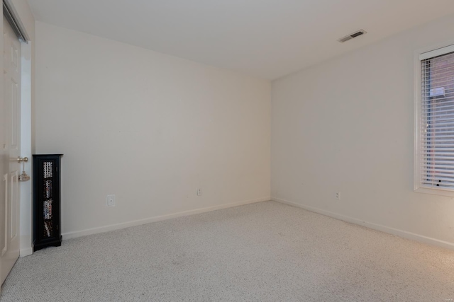 unfurnished room with light carpet, visible vents, and baseboards