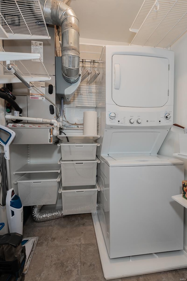 laundry area with stacked washer / drying machine and laundry area