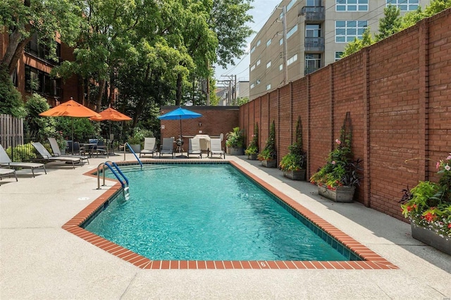 pool featuring fence and a patio